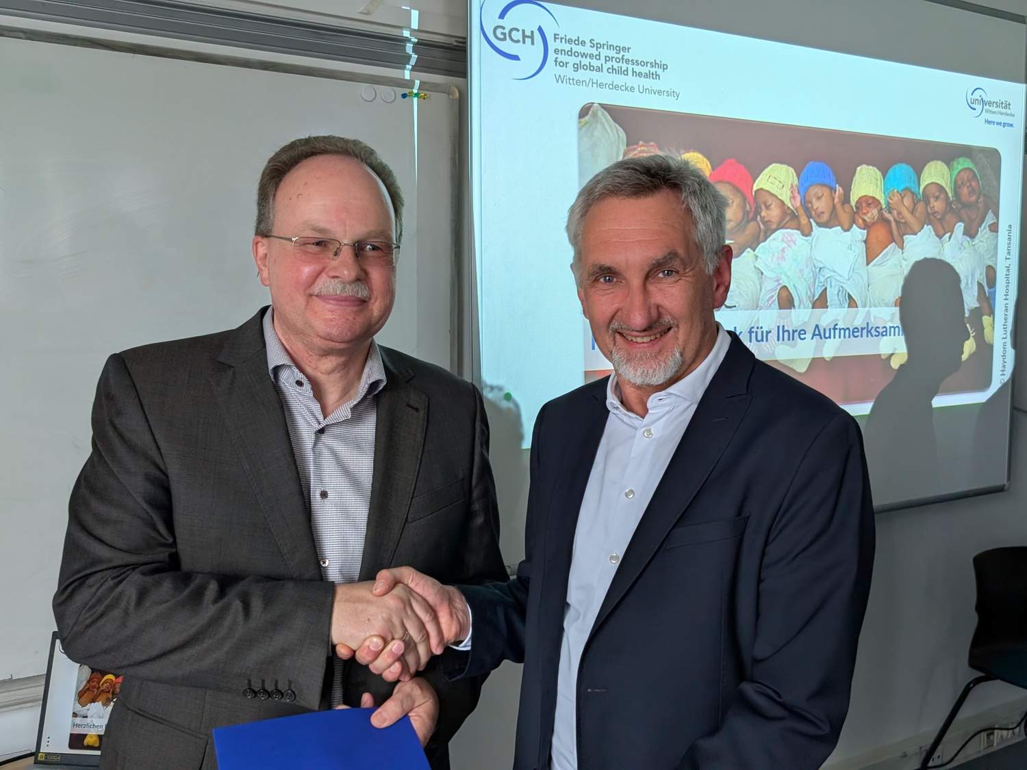 Prof. Dr. Michael Paulussen von der Universität Witten/Herdecke (rechts) überreicht die Ernennungsurkunde an apl. Prof. Dr. Carsten Krüger.