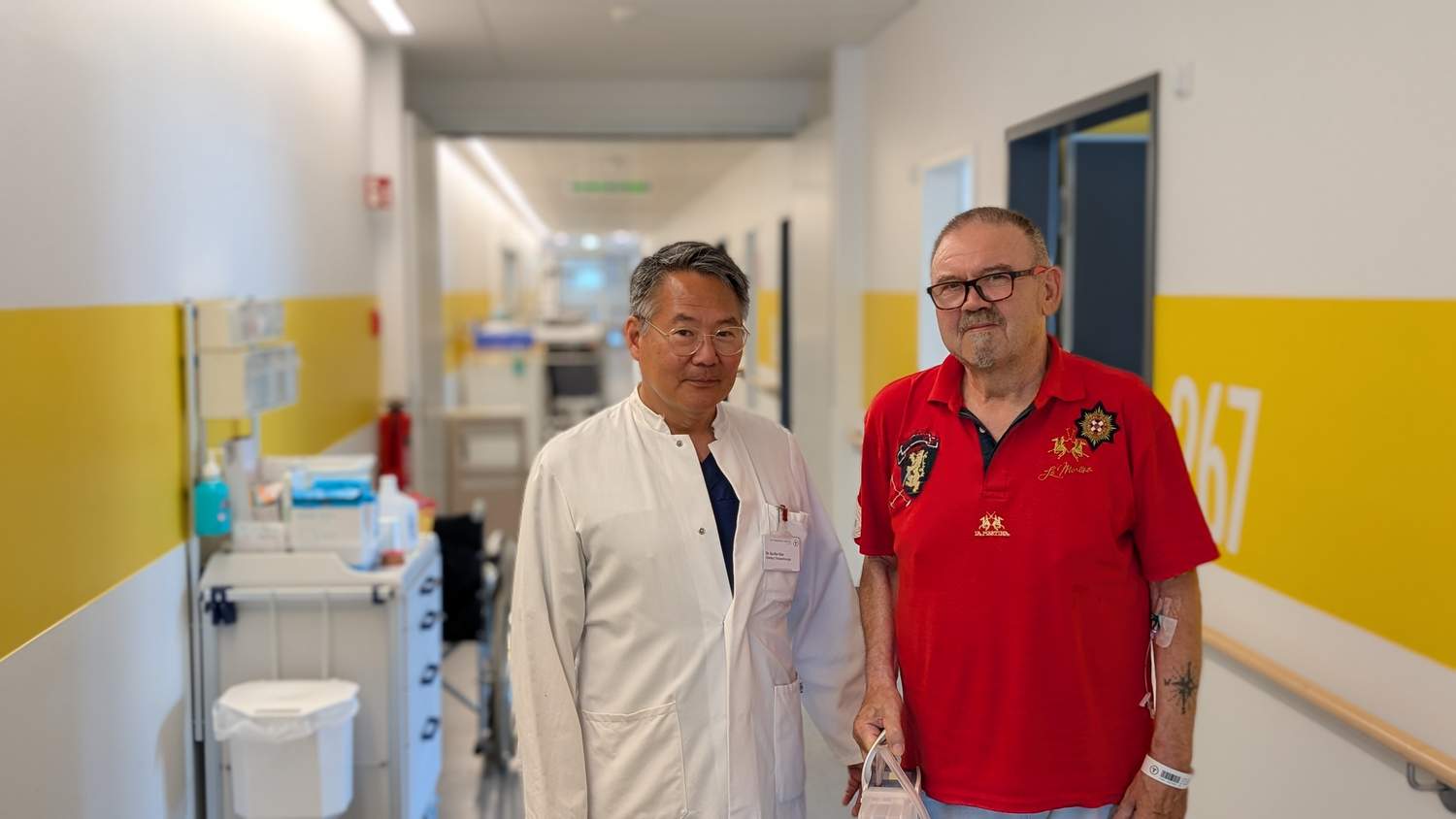 Patient Ralf Thaele aus Hamm und Su-Sin Kim, Chefarzt der Thoraxchirurgie am St. Franziskus-Hospital in Ahlen. Fünf Tage nach der Operation stehen schon Spaziergänge auf dem Flur auf dem Programm. (Bild: St. Franziskus-Hospital Ahlen)